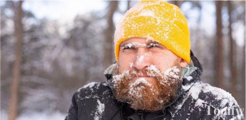 adult man face covers in snow